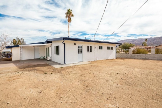 back of property featuring a mountain view and a patio area