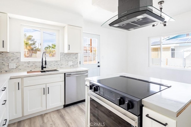 kitchen featuring sink, white cabinetry, electric range oven, stainless steel dishwasher, and island exhaust hood