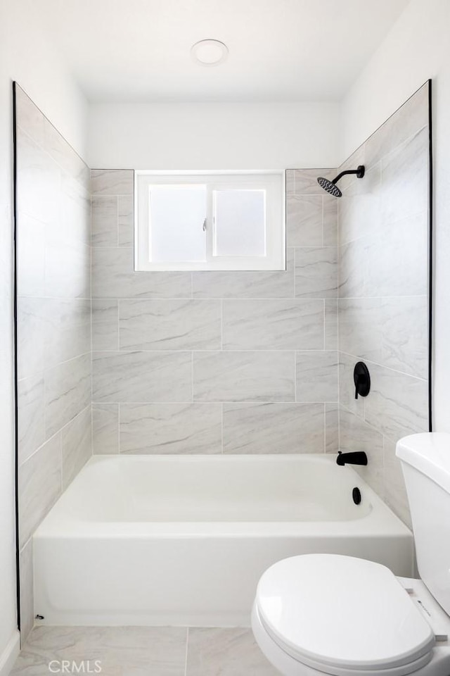 bathroom with tiled shower / bath and toilet