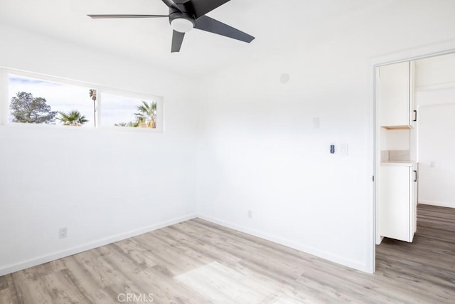 empty room with ceiling fan and light wood-type flooring