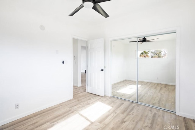 unfurnished bedroom with light hardwood / wood-style floors, a closet, and ceiling fan