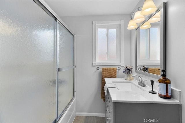 bathroom featuring vanity, hardwood / wood-style floors, and enclosed tub / shower combo