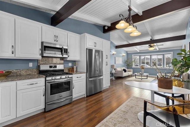 kitchen featuring stainless steel appliances, decorative light fixtures, and white cabinets