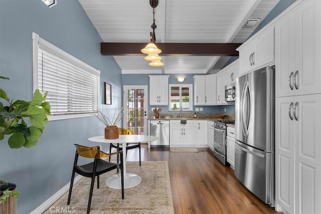 kitchen with dark hardwood / wood-style floors, pendant lighting, stainless steel appliances, light stone countertops, and white cabinets