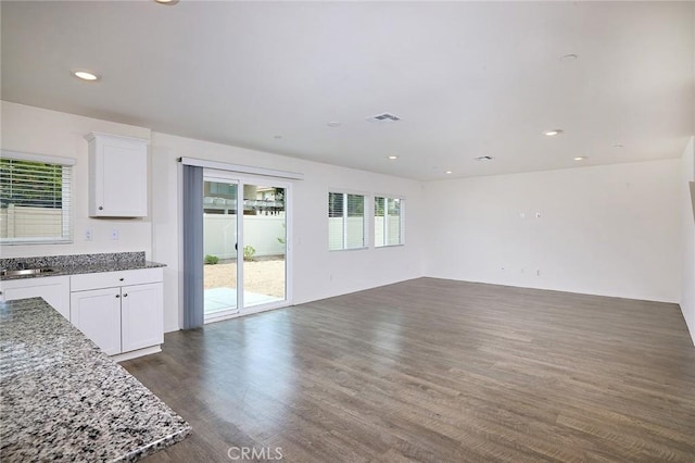 kitchen with stone counters, dark hardwood / wood-style floors, sink, and white cabinets