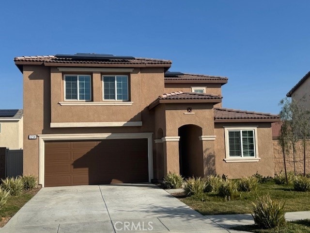 mediterranean / spanish house featuring a garage and solar panels