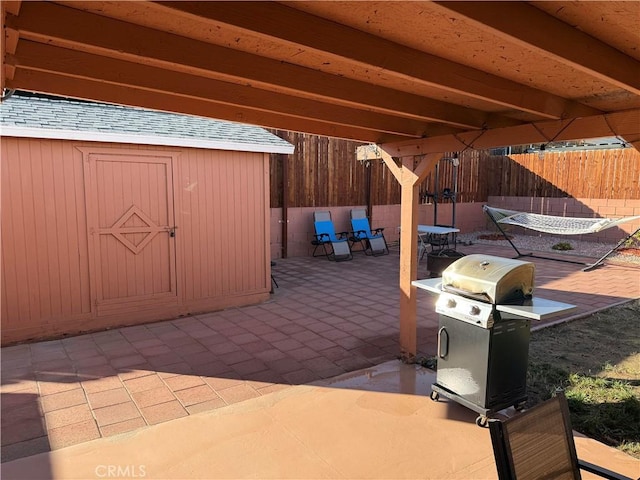 view of patio / terrace featuring a grill and a storage shed