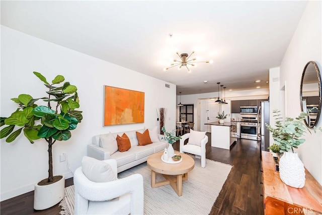 living room featuring a notable chandelier and dark wood-type flooring