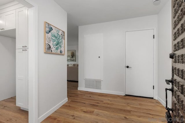 corridor with light hardwood / wood-style floors