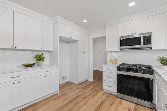 kitchen featuring white cabinetry, appliances with stainless steel finishes, and light stone countertops