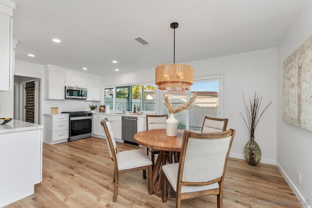 dining room featuring sink and light hardwood / wood-style floors