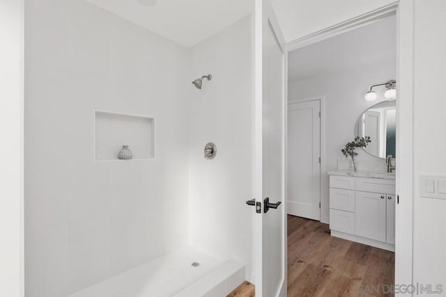 bathroom with vanity, wood-type flooring, and a tile shower