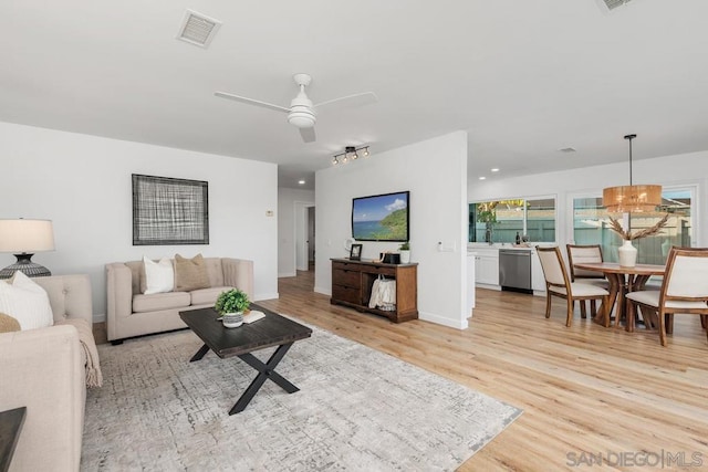 living room with ceiling fan and light hardwood / wood-style floors