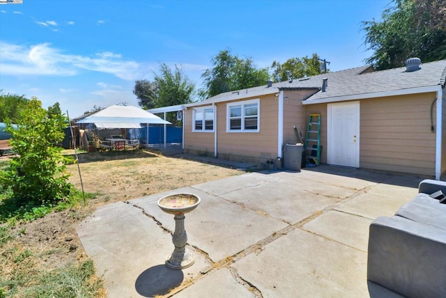 rear view of house featuring a gazebo, a yard, and a patio area