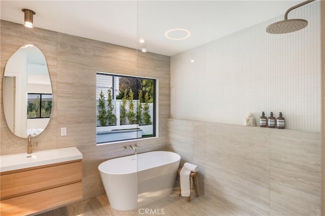 bathroom with tile walls, plus walk in shower, and vanity