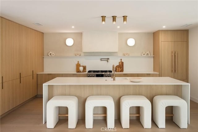 kitchen featuring a spacious island, a breakfast bar area, and stainless steel gas stovetop