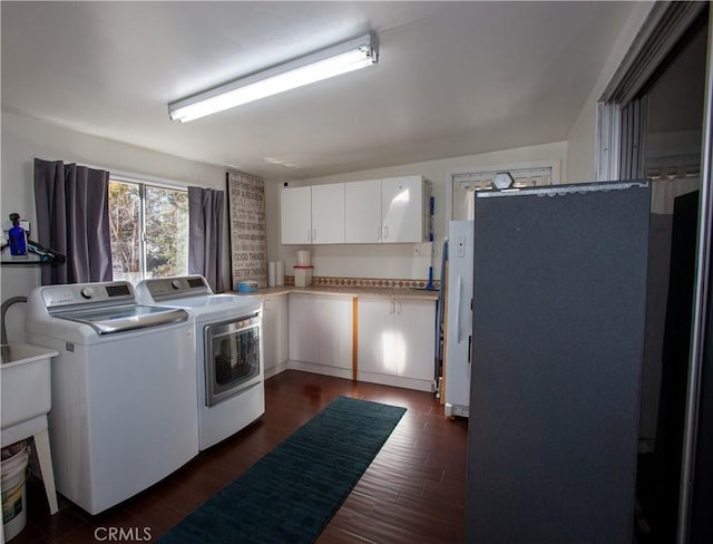 washroom with cabinets, dark wood-type flooring, and independent washer and dryer