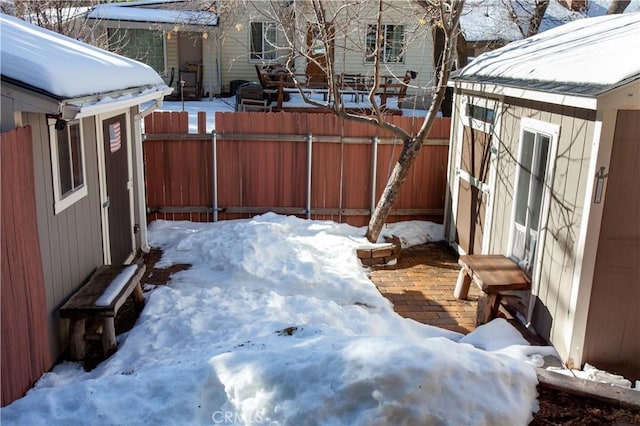 yard layered in snow with an outbuilding