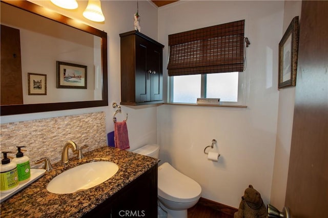 bathroom with vanity, toilet, and decorative backsplash