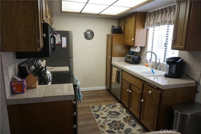 kitchen with dark hardwood / wood-style flooring, dishwasher, sink, and range with electric stovetop