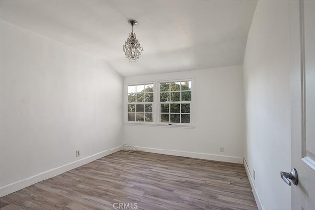 unfurnished room with vaulted ceiling and light hardwood / wood-style floors