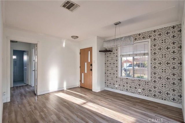 empty room with crown molding and hardwood / wood-style floors