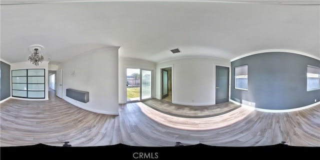 interior space with hardwood / wood-style flooring, a chandelier, and vaulted ceiling