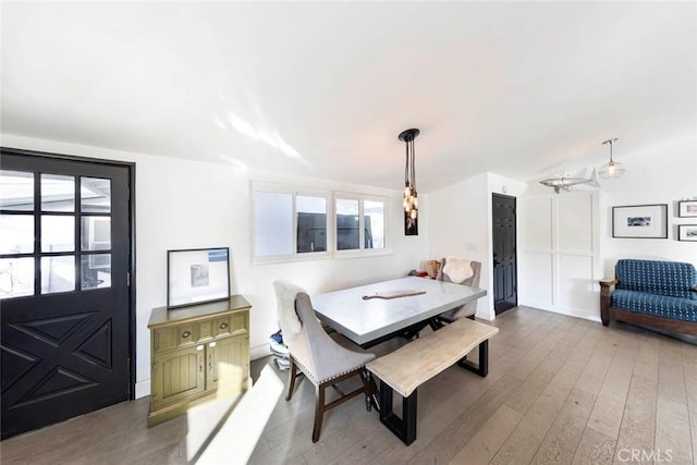 dining room with lofted ceiling, wood finished floors, and a healthy amount of sunlight