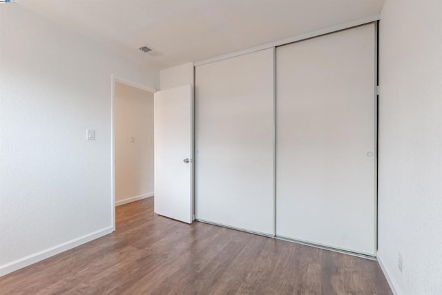 unfurnished bedroom with wood-type flooring and a closet