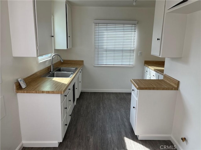 kitchen featuring dark hardwood / wood-style flooring, sink, and white cabinets