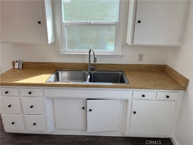 kitchen featuring white cabinetry and a sink