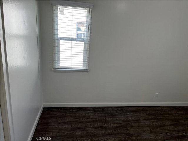 empty room featuring baseboards and wood finished floors