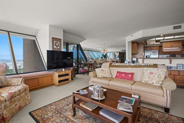 carpeted living room with a notable chandelier