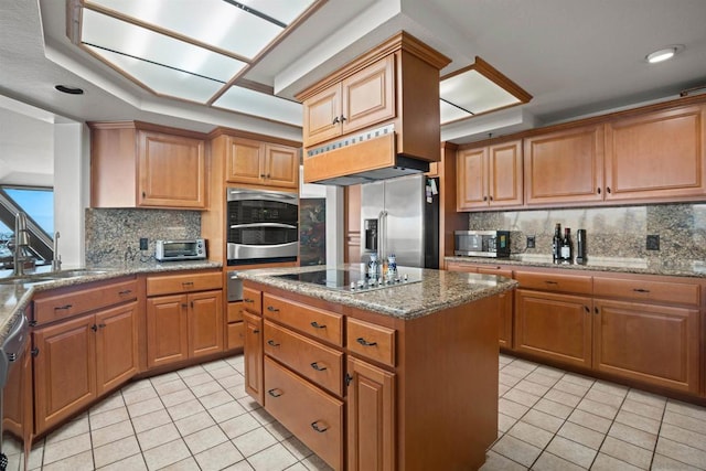 kitchen featuring light tile patterned flooring, sink, stone countertops, a center island, and stainless steel appliances