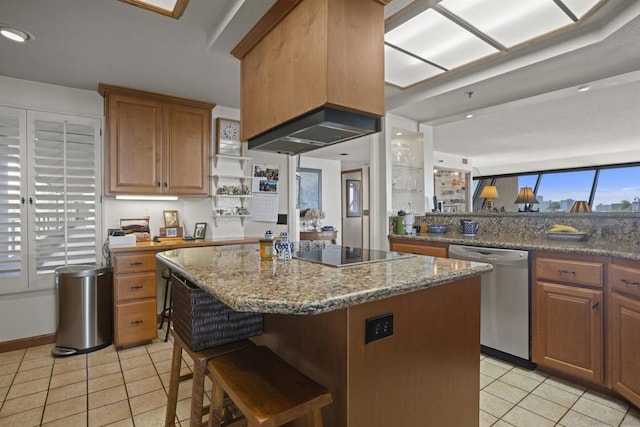 kitchen featuring a breakfast bar, stone countertops, a center island, stainless steel dishwasher, and black electric stovetop