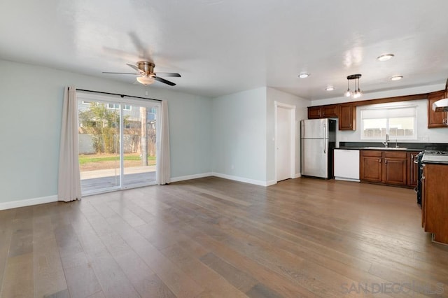 kitchen featuring stainless steel appliances, a healthy amount of sunlight, hardwood / wood-style floors, and decorative light fixtures