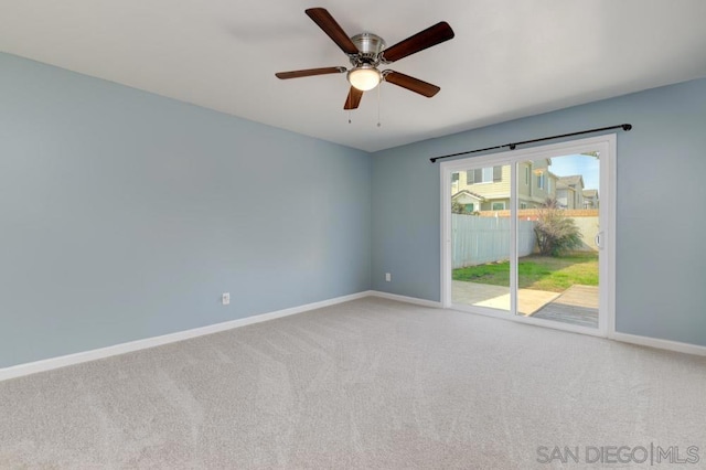 carpeted spare room featuring ceiling fan