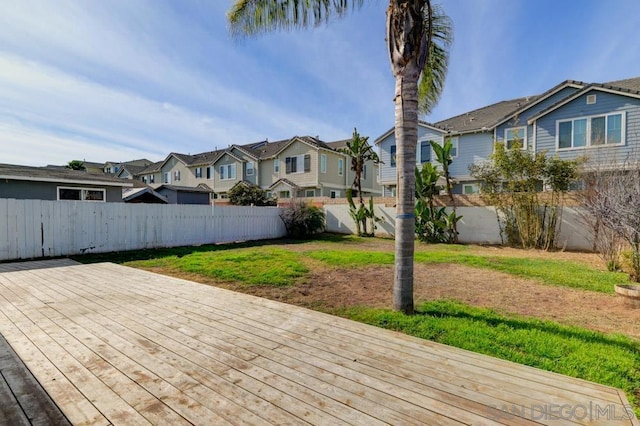 wooden terrace featuring a patio area and a lawn