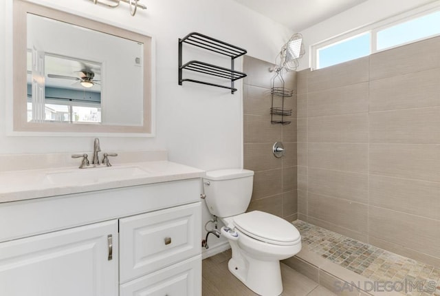 bathroom featuring vanity, toilet, and tiled shower