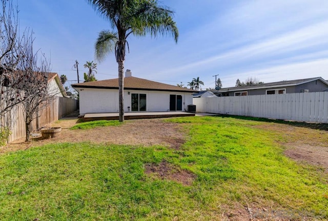 rear view of house with a yard and central air condition unit