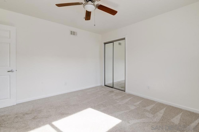 unfurnished bedroom featuring light carpet, a closet, and ceiling fan