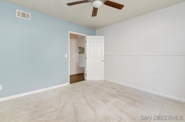 spare room with ceiling fan and light carpet