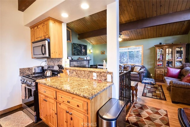 kitchen featuring vaulted ceiling with beams, tasteful backsplash, kitchen peninsula, stainless steel appliances, and light hardwood / wood-style floors