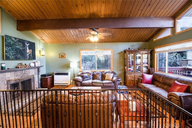 living room featuring heating unit, a tiled fireplace, a wealth of natural light, and lofted ceiling with beams