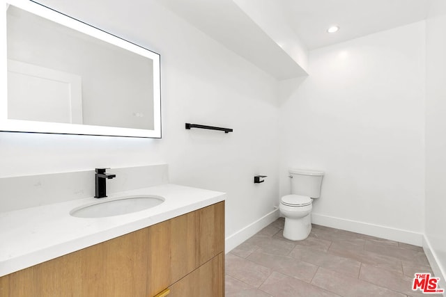 bathroom with vanity, tile patterned flooring, and toilet