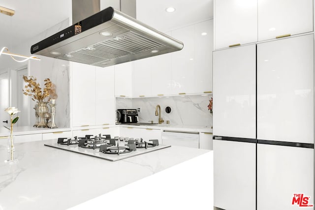 kitchen featuring island exhaust hood, sink, pendant lighting, white appliances, and white cabinets