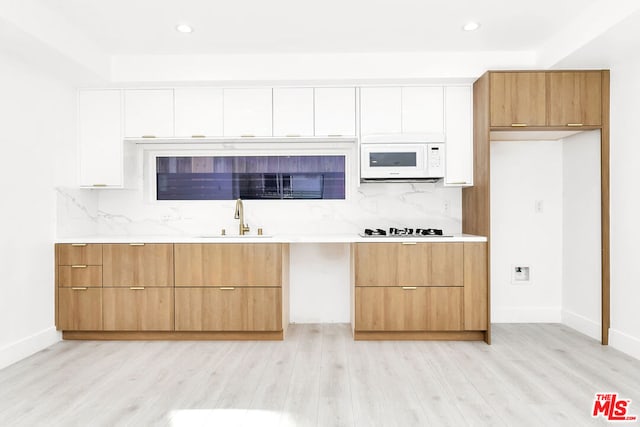 kitchen featuring white cabinetry, white appliances, tasteful backsplash, and light wood-type flooring