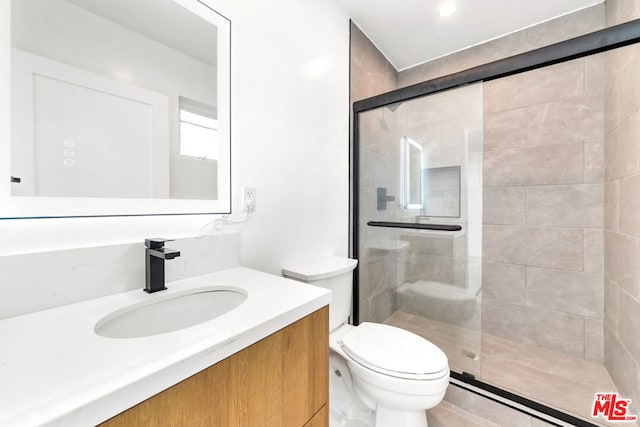 bathroom with vanity, toilet, and a shower with shower door