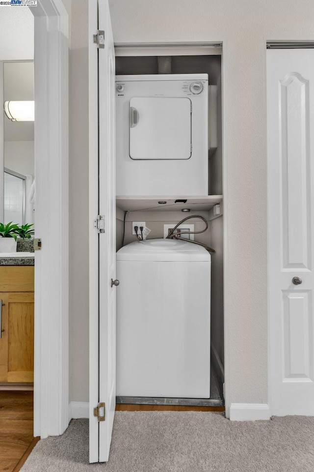 washroom featuring light carpet and stacked washing maching and dryer