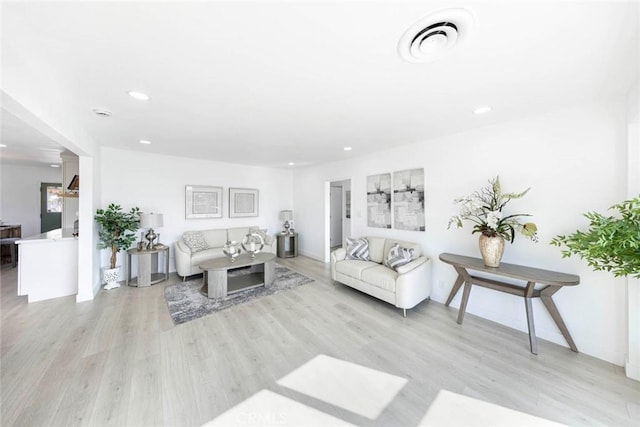 living area with light wood-type flooring, visible vents, and recessed lighting